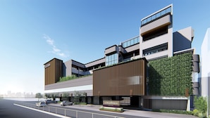 A modern building with multiple floors, large windows, and a green wall. - Citadines Amigo Iloilo (Iloilo)