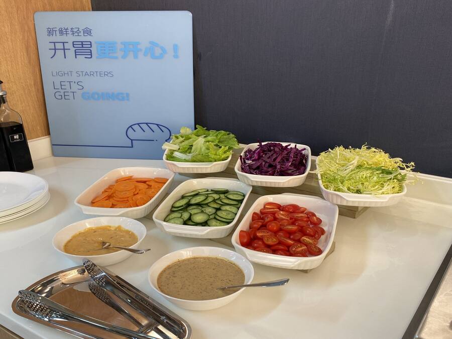 A buffet table with various food items and condiments.