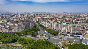 Un hotel de gran altura con varios pisos, un patio central y vistas de la ciudad circundante.