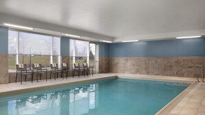 A swimming pool with chairs and a view of the outdoors. - Holiday Inn Express & Suites Aurora by IHG (Aurora)