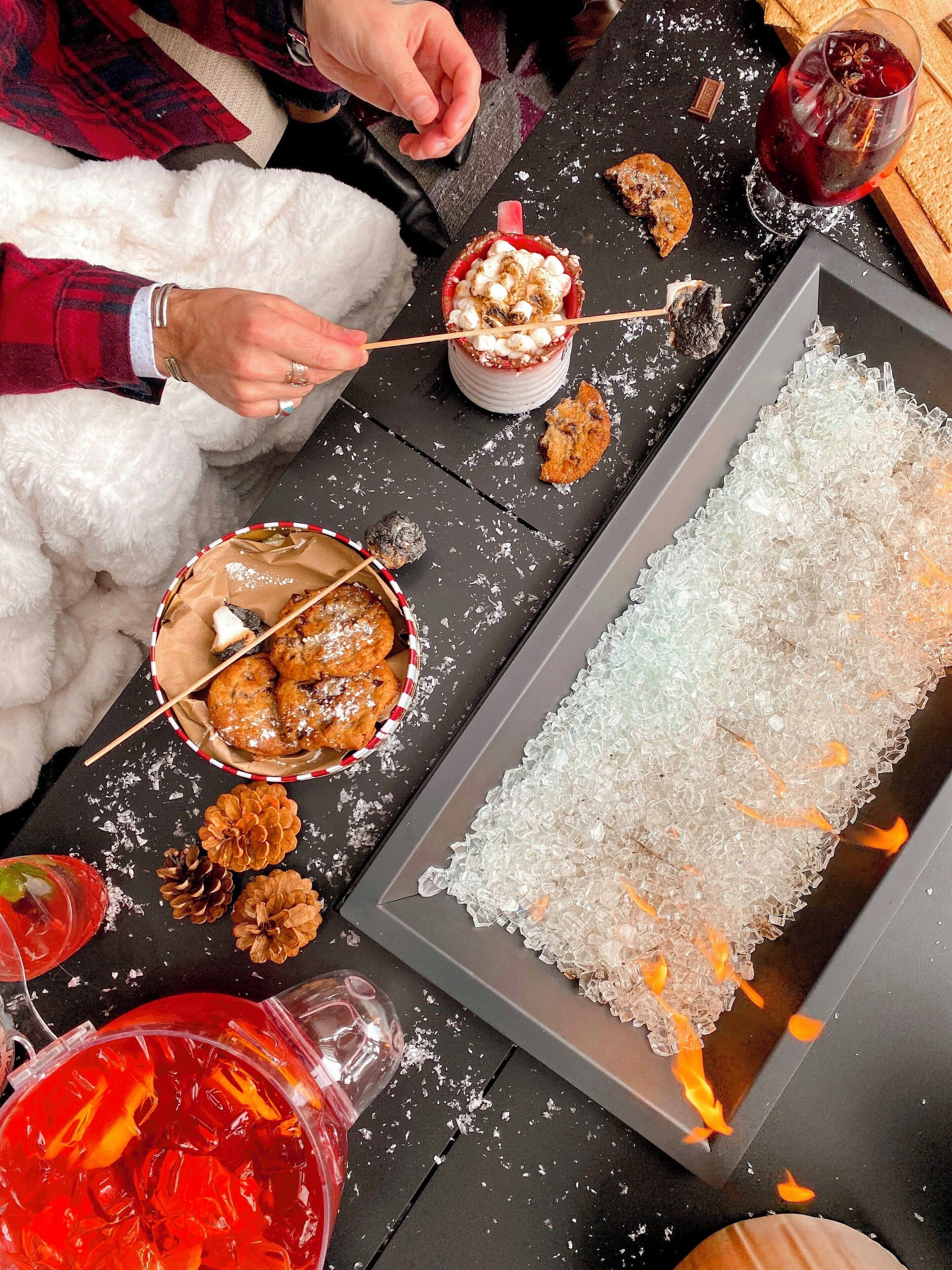 A table with a dessert, a tray of ice, and a drink.