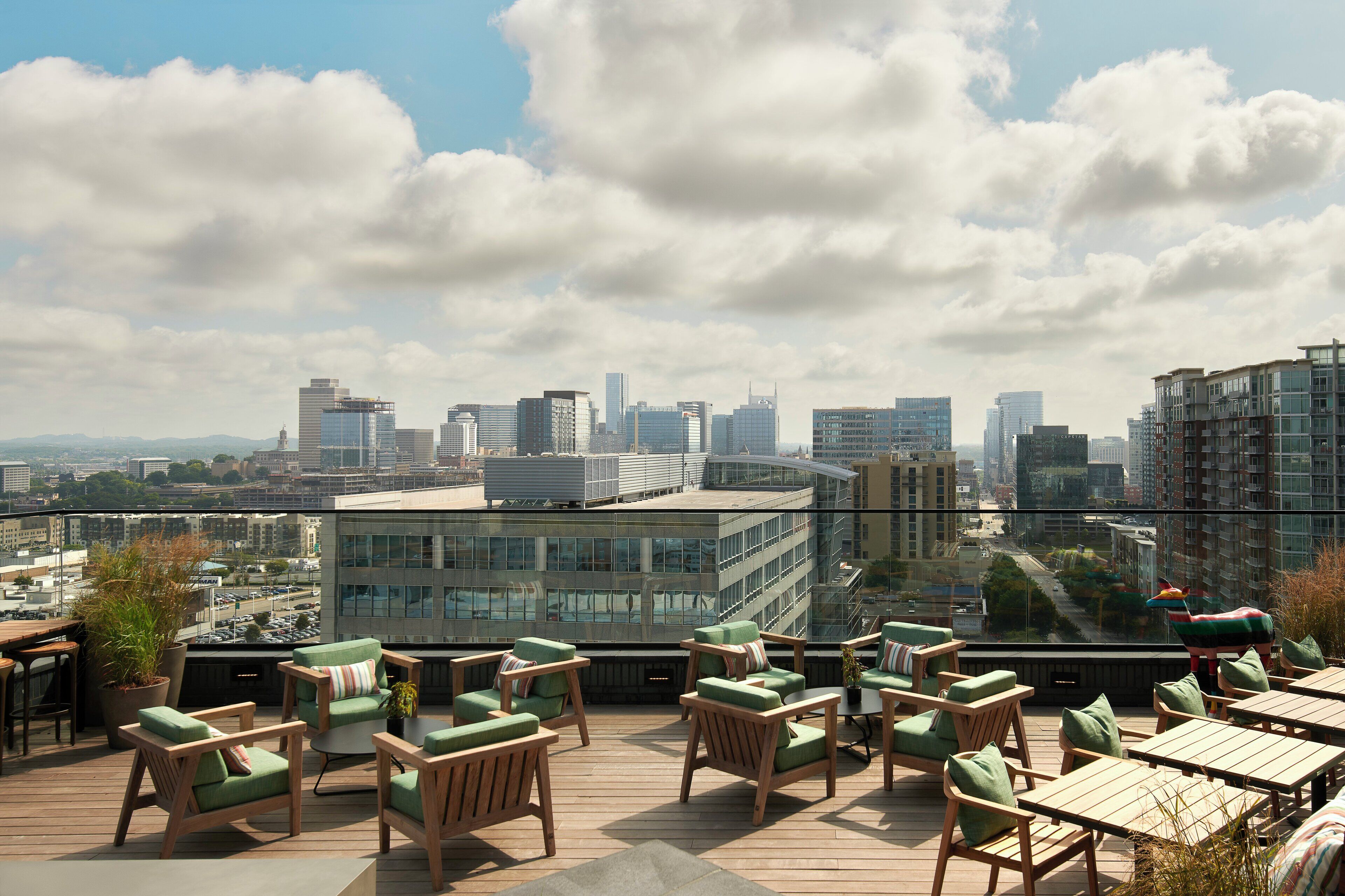 Terraza en la azotea con asientos exteriores y vista panorámica de la ciudad.