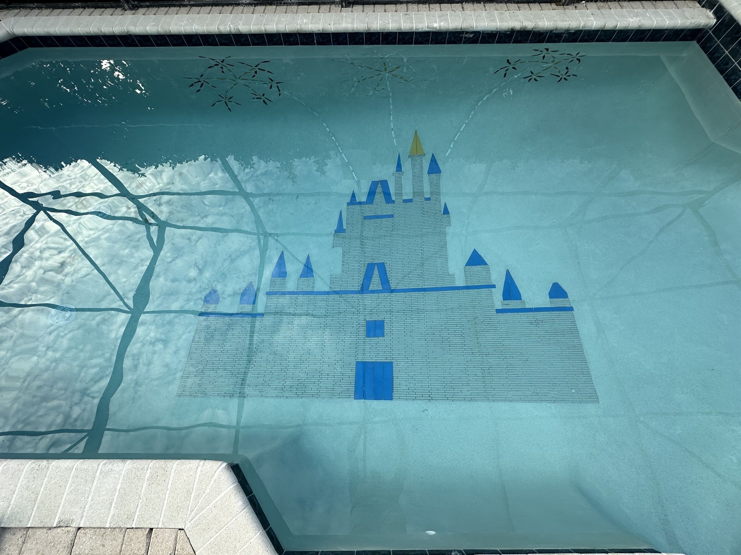 A swimming pool with a castle mural on the wall.