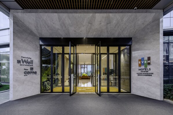 A hotel entrance with a glass door, a sign reading "Well you're looking good," and a logo for "EVEN Hotels." - EVEN Hotel Nanjing Yangtze River by IHG (Nanjing)
