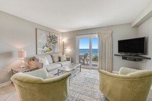 Relax in this stylish living room with a comfortable sofa set, armchairs, and a flat-screen TV.