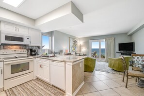 Enjoy meals in the kitchen with oven, microwave, and dishwasher, and dine in the adjacent dining area with a view of the ocean.
