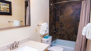 A bathroom with a sink, toilet, and shower area. - Fawn Valley Inn: 303 (Estes Park)