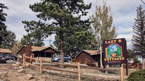 A rustic wooden building labeled "Lazy R Cottages" with a sign indicating vacancies. - Lazy R Cottages: 7A (Estes Park)