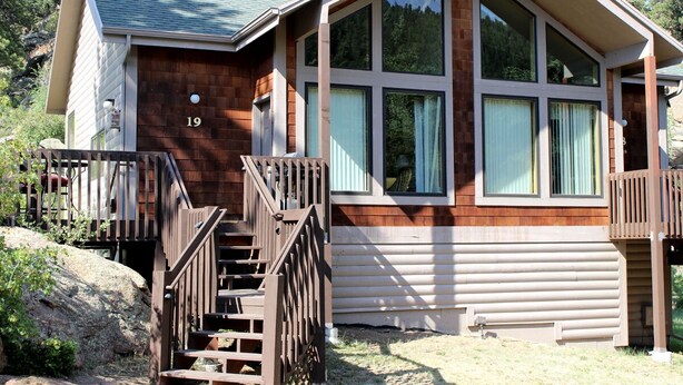 Une cabane avec une façade en bois, de grandes fenêtres et le numéro « 19 » sur la porte.