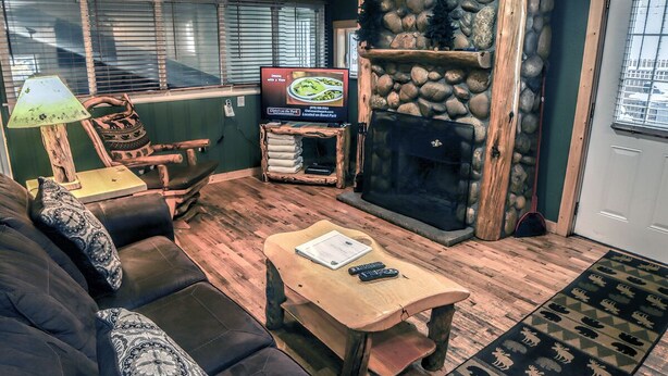 A cozy living room with a fireplace, a television, a sofa, and a coffee table.