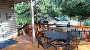 A covered deck with a grill, dining table, and chairs. - Sunnyside Knoll: 16 (Estes Park)
