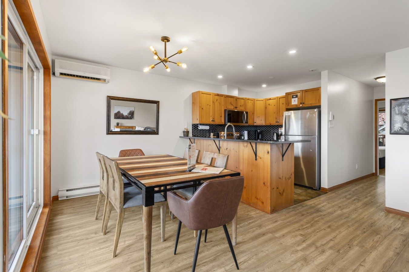A modern kitchen with wooden cabinets, a built-in island, and a stainless steel refrigerator.