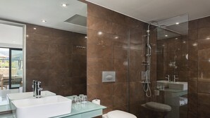 A modern bathroom with a glass-enclosed shower, a white sink, and a toilet. - Chq Galini Palace (Platanias)