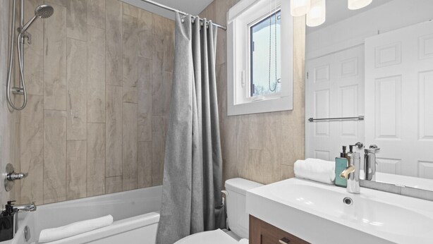 A bathroom with a bathtub, toilet, and shower.