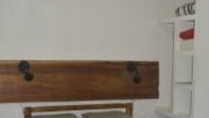 Una cama individual con cabecera de madera y colcha estampada.