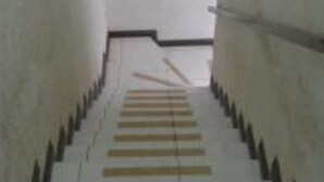 Una escalera con barandilla que sube.