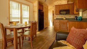 A wooden interior with a dining area, kitchen, and living space. - West Glacier Cabin Village (West Glacier)