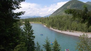A river surrounded by dense forest and mountains. - West Glacier Cabin Village (West Glacier)