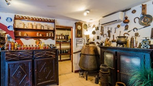 Une cuisine rustique avec des meubles de rangement en bois, des étagères remplies de bocaux et divers ustensiles de cuisine.