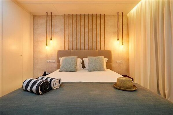 A hotel room with a bed, a suitcase, and a hat on the bed. - Oura Senses (Albufeira)