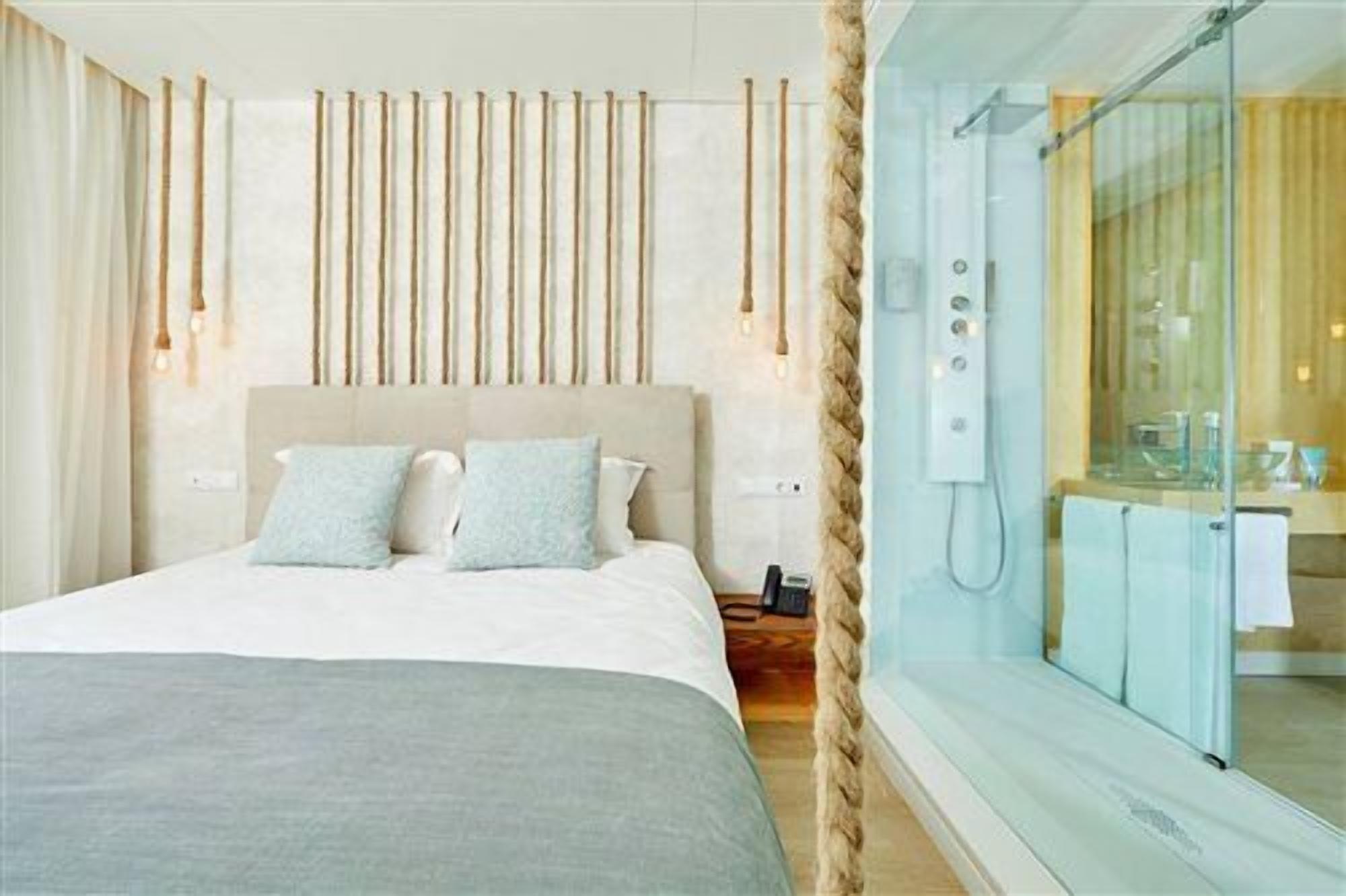 Une chambre d’hôtel avec un lit, une table de chevet et une cabine de douche en verre.
