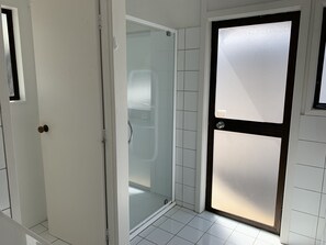 Bathroom features a glass shower enclosure with a black frame and silver handle.