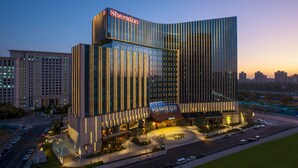 A modern Sheraton hotel with a curved glass facade, multiple floors, and a well-lit entrance area. - Sheraton Beijing Lize Hotel (Beijing)