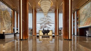 A spacious lobby with a large chandelier, tall columns, and a central sculpture. - Sheraton Beijing Lize Hotel (Beijing)