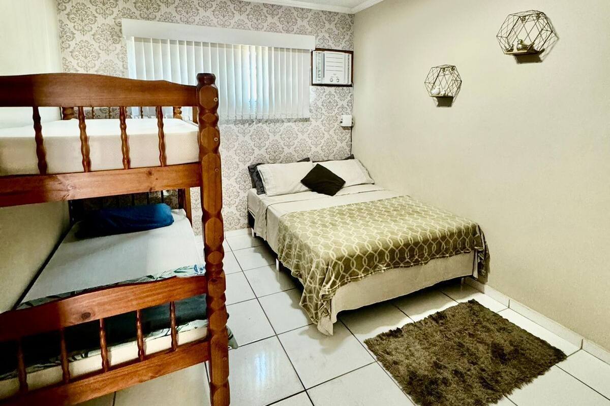 Un dormitorio con una cama doble, una cama individual y una alfombra pequeña.