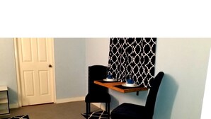 A room with two black chairs, a small wooden table, and a patterned curtain. - Careffe Suites Studio 4 - 5 mins to from Rodney Bay Village (Monchy)