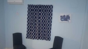 A room with two chairs, a patterned wall hanging, and a small painting. - Careffe Suites Studio 4 - 5 mins to from Rodney Bay Village (Monchy)