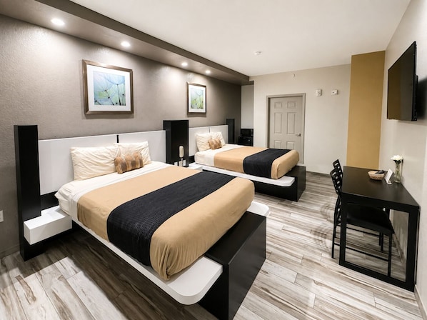 Une chambre d’hôtel avec deux lits, un bureau et une chaise.