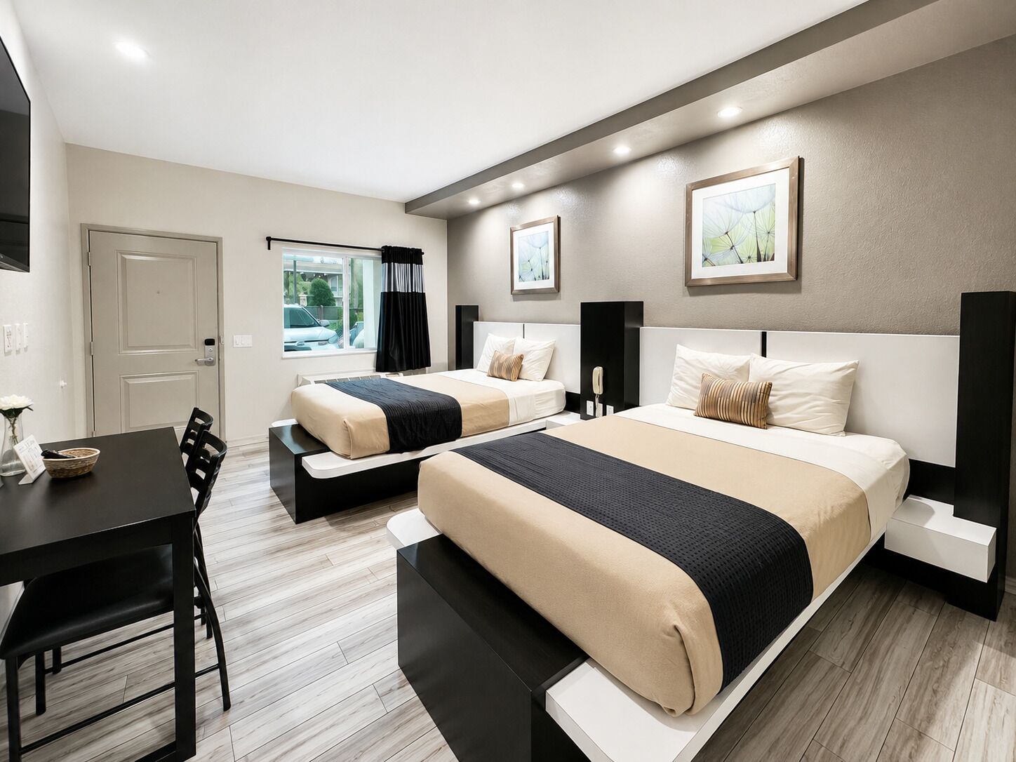 Habitación de hotel con dos camas, una mesa de comedor y una ventana con cortinas.
