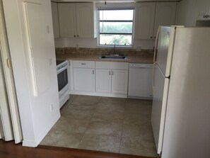Kitchen features an oven, dishwasher, and window above the sink.