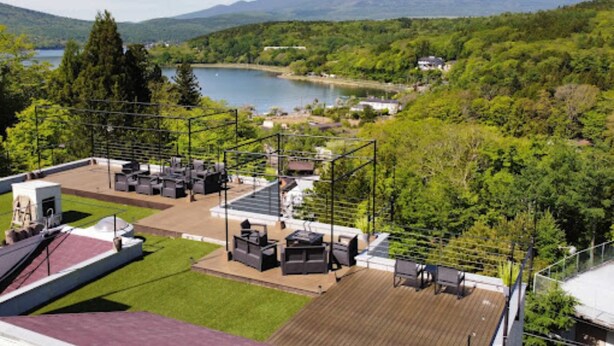 A rooftop terrace with outdoor seating and a view of a mountain. - Rokumeikan HILLS (Yamanakako)