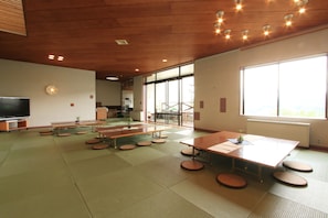 Relax in this serene space with a large window, tatami mats, and a small plant, perfect for unwinding.