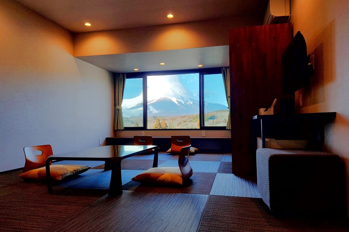 A modern room with a large window offering a view of a snow-capped mountain.
