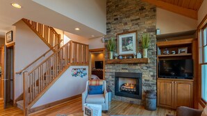A spacious living room with a fireplace, a wooden staircase, and a cozy seating area. - B Rock Ridge at Echota - townhome with private hot tub! (Banner Elk)