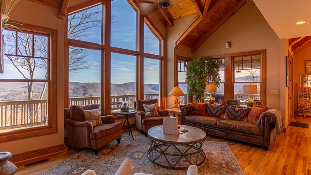 A spacious living room with large windows, a ceiling fan, and a cozy seating area. - B Rock Ridge at Echota - townhome with private hot tub! (Banner Elk)