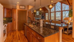 A spacious kitchen with granite countertops, wooden cabinets, and a stone backsplash. - B Rock Ridge at Echota - townhome with private hot tub! (Banner Elk)