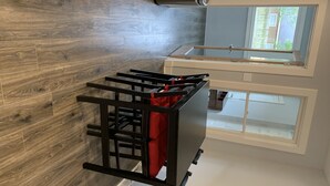 Ett modernt kök med trägolv, en inbyggd spis och ett fönster med utsikt över ett bostadsområde.