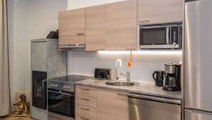 Una cocina moderna con electrodomésticos de acero inoxidable, microondas, cafetera y tostadora.