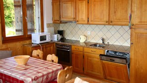 Una cocina con armarios de madera, microondas, estufa y lavavajillas.