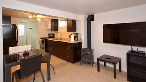 A compact living space with a kitchenette, a dining area, a TV, and a fireplace.