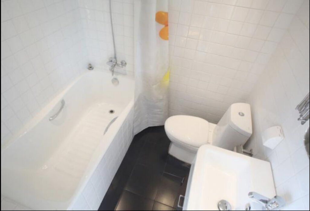A bathroom with a bathtub, toilet, and sink.