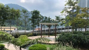 A landscaped outdoor area with a gazebo, pathways, and greenery.