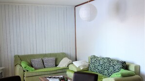 A living room with a green sofa, a coffee table, and a dining table with chairs. - Magrappé M 544 - SKI LIFT studio 4 pers (Veysonnaz)