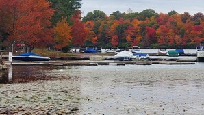 Ein Yachthafen mit vertäuten Booten, umgeben von Bäumen in Herbstfarben.