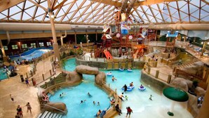 Ein großer Indoor-Wasserpark mit mehreren Pools, Rutschen und Wasserspielbereichen.