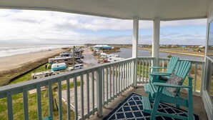 A covered porch with a view of a beach and RVs parked nearby. - RENOVATED BEACHSIDE Condo-Elevator-Heated Pool-in unit Washer/Dryer  (Galveston)